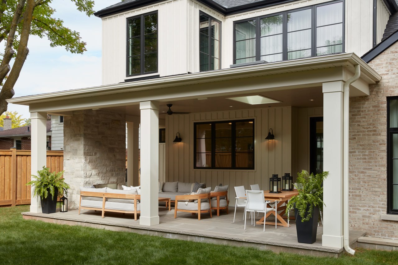 Covered outdoor patio of an Oakville custom home with stone accent wall and white columns