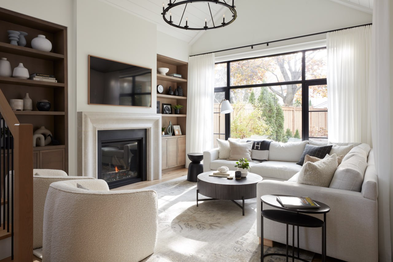 Custom great room with cathedral ceiling, stone fireplace surround and built-in shelving in Oakville