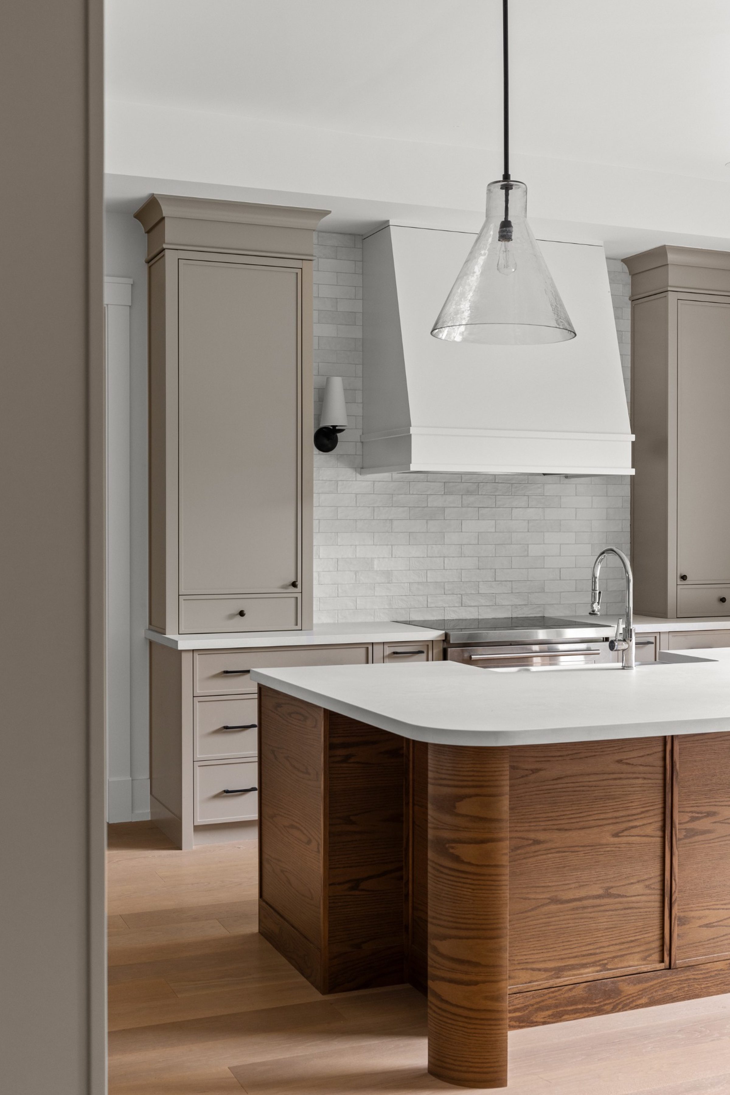 Luxury custom kitchen in Oakville by Prasada Custom Homes featuring a solid wood island, quartz countertop, custom cabinetry, and statement pendant lighting