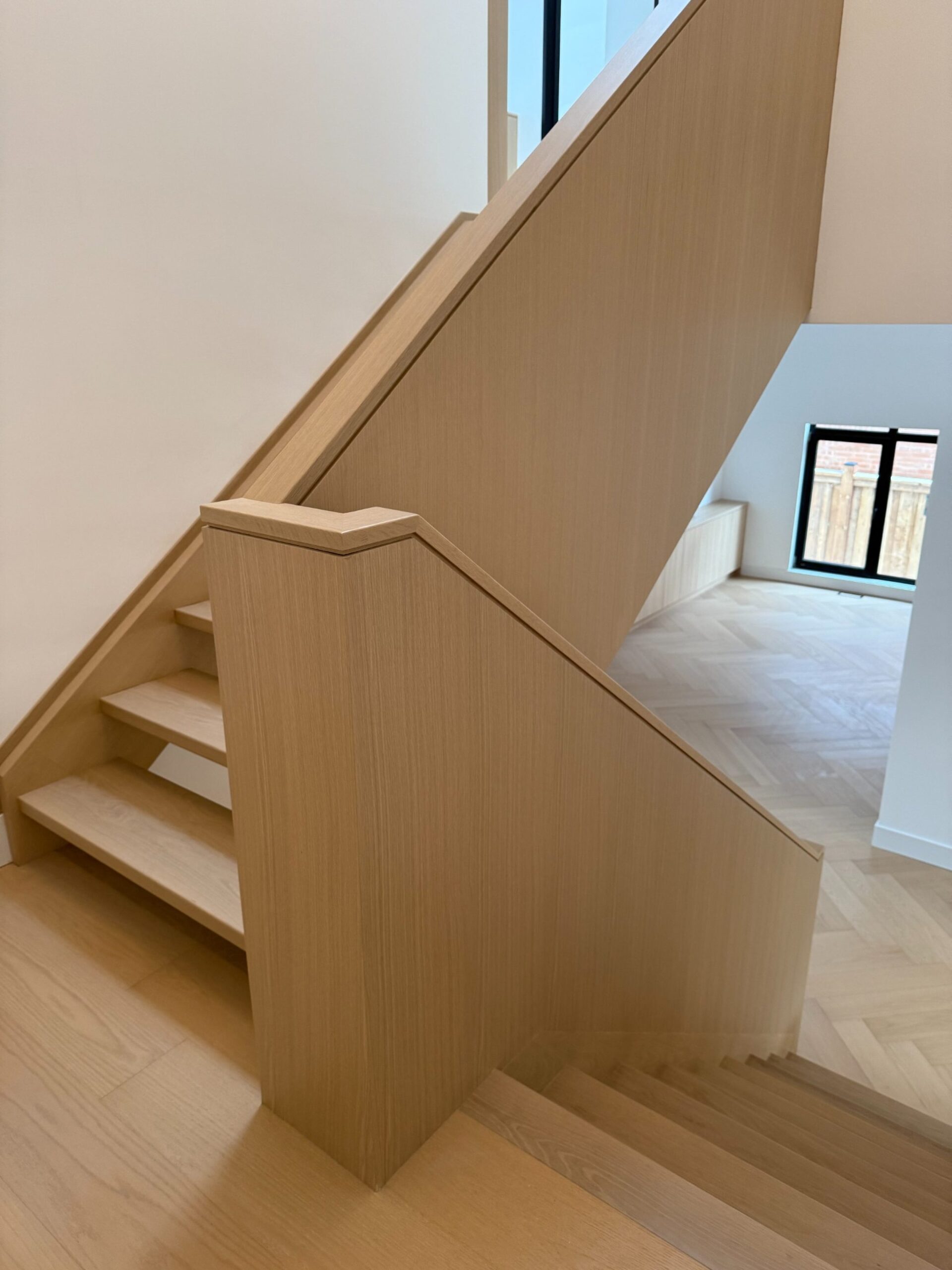 Custom wood staircase detail in a luxury Oakville home by Prasada Custom Homes, featuring integrated wood guard, clean joinery, and minimalist architectural design