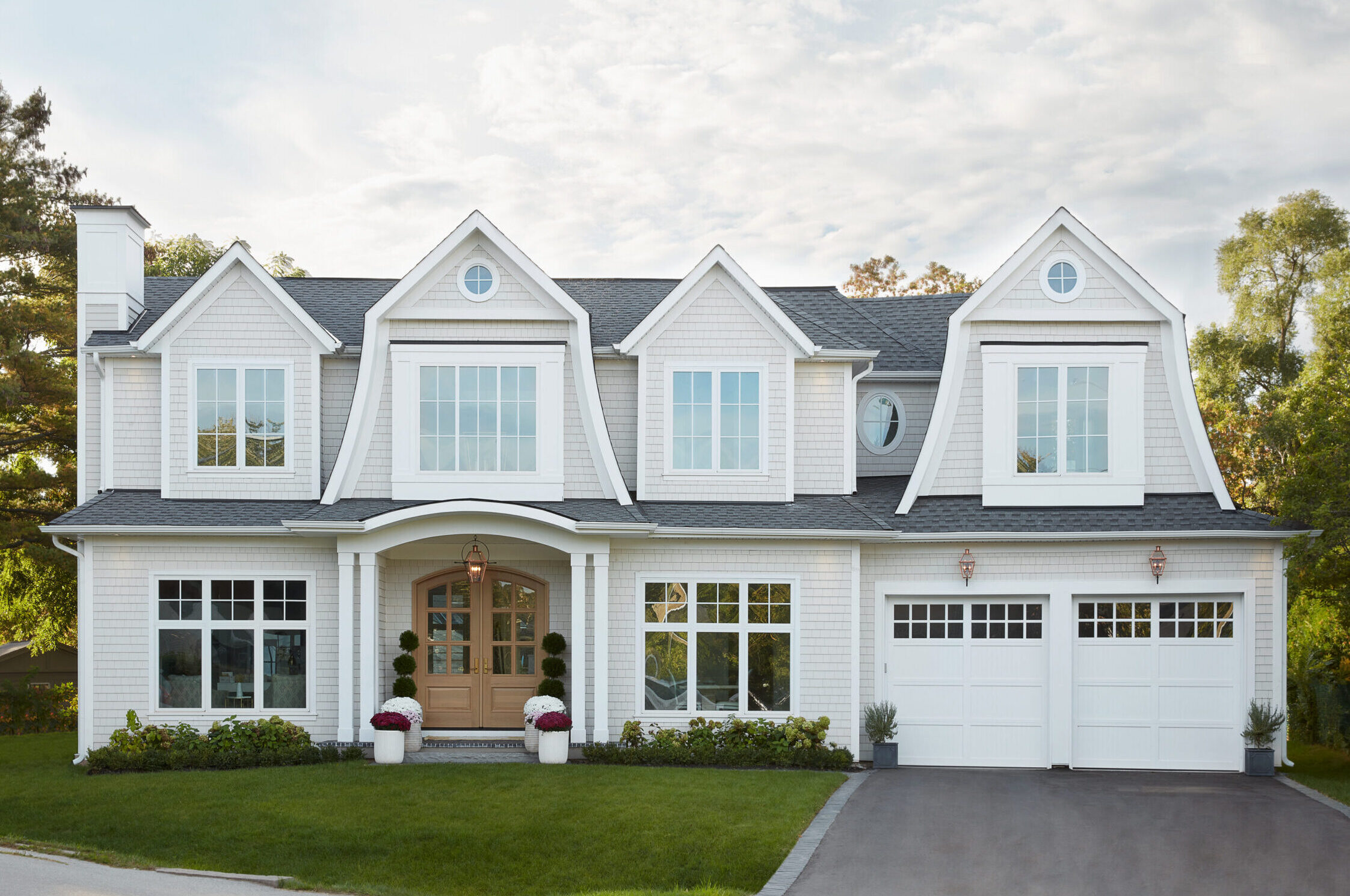Luxury custom home exterior in Oakville built by Prasada Custom Homes, featuring timeless architecture, white siding, black windows, and refined detailing